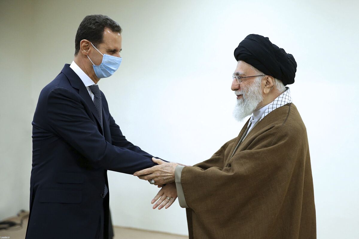 In this picture released by the official website of the office of the Iranian supreme leader, Supreme Leader Ayatollah Ali Khamenei, right, and Syrian President Bashar Assad shake hands at the start of their meeting, in Tehran, Iran, Sunday, May 8, 2022. Nour News, close to Iran's security apparatus, said in the Sunday report that Assad met Ayatollah Khamenei and President Ebrahim Raisi earlier in the day. (Office of the Iranian Supreme Leader via AP)