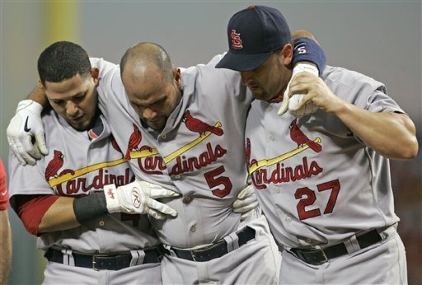 St. Louis Cardinals' Albert Pujols (5) is helped off the field by Yadier Molina (4) and Ron Villone (27) after Pujols injured his left leg batting in the seventh inning of a baseball game against the Cincinnati Reds, Tuesday, June 10, 2008, in Cincinnati. (AP Photo/Al Behrman)