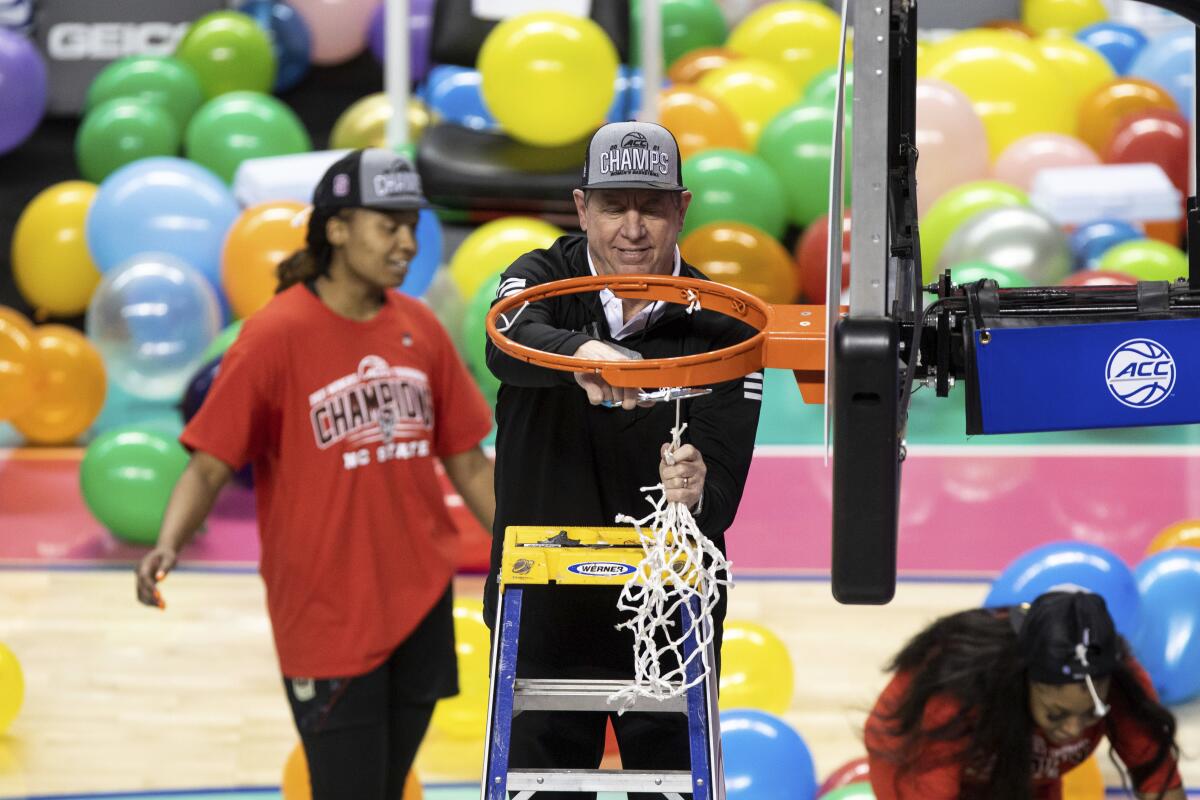 North Carolina State head coach Wes Moore cuts down the net after his team defeated Louisville in the championship of the Atlantic Coast Conference NCAA women's college basketball game in Greensboro, N.C., Sunday, March 7, 2021. (AP Photo/Ben McKeown)
