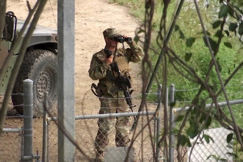 FILE - In this April 10, 2018, file frame from video, a National Guard troop watches over Rio Grande River on the border in Roma, Texas. The deployment of National Guard members to the U.S.-Mexico border at President Donald Trump's request was underway with a gradual ramp-up of troops under orders to help curb illegal immigration. (AP Photo/John Mone, File)