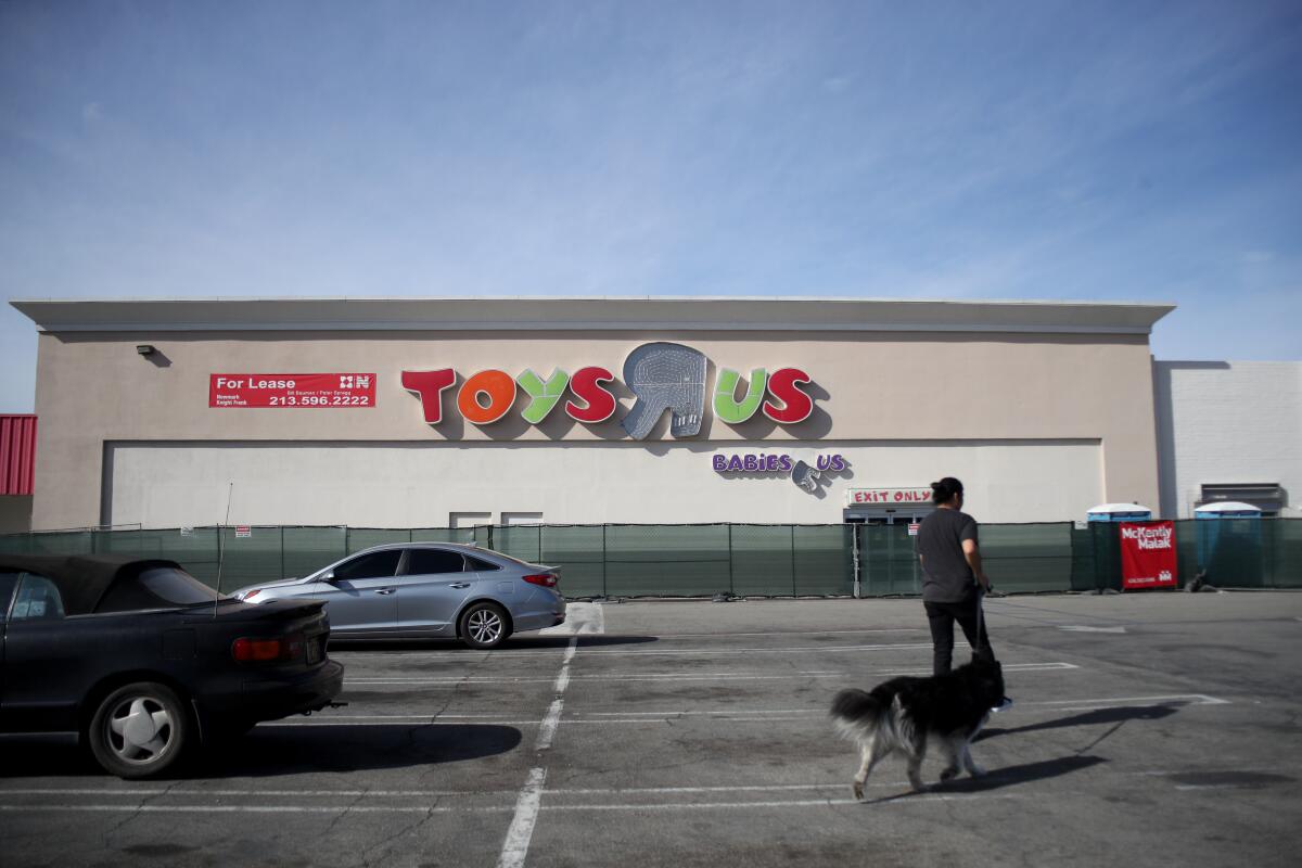 A sparse parking lot and a former Toys 'R' Us building