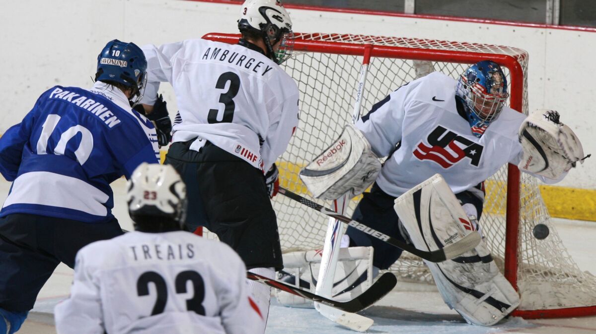 U.S. goalie Brandon Maxwell catches the puck as teammate Tyler Amburgey moves in to defend against Finland's Joonas Hurri during a 2008 tournament in Lake Placid, N.Y.