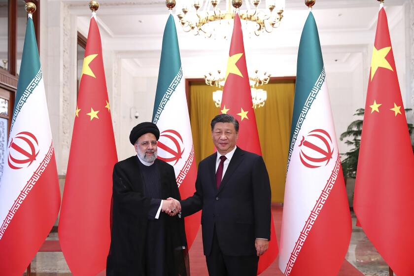 In this photo released by the official website of the office of the Iranian Presidency, President Ebrahim Raisi, left, shakes hands with his Chinese counterpart Xi Jinping in an official welcoming ceremony in Beijing, Tuesday, Feb. 14, 2023. (Iranian Presidency Office via AP)