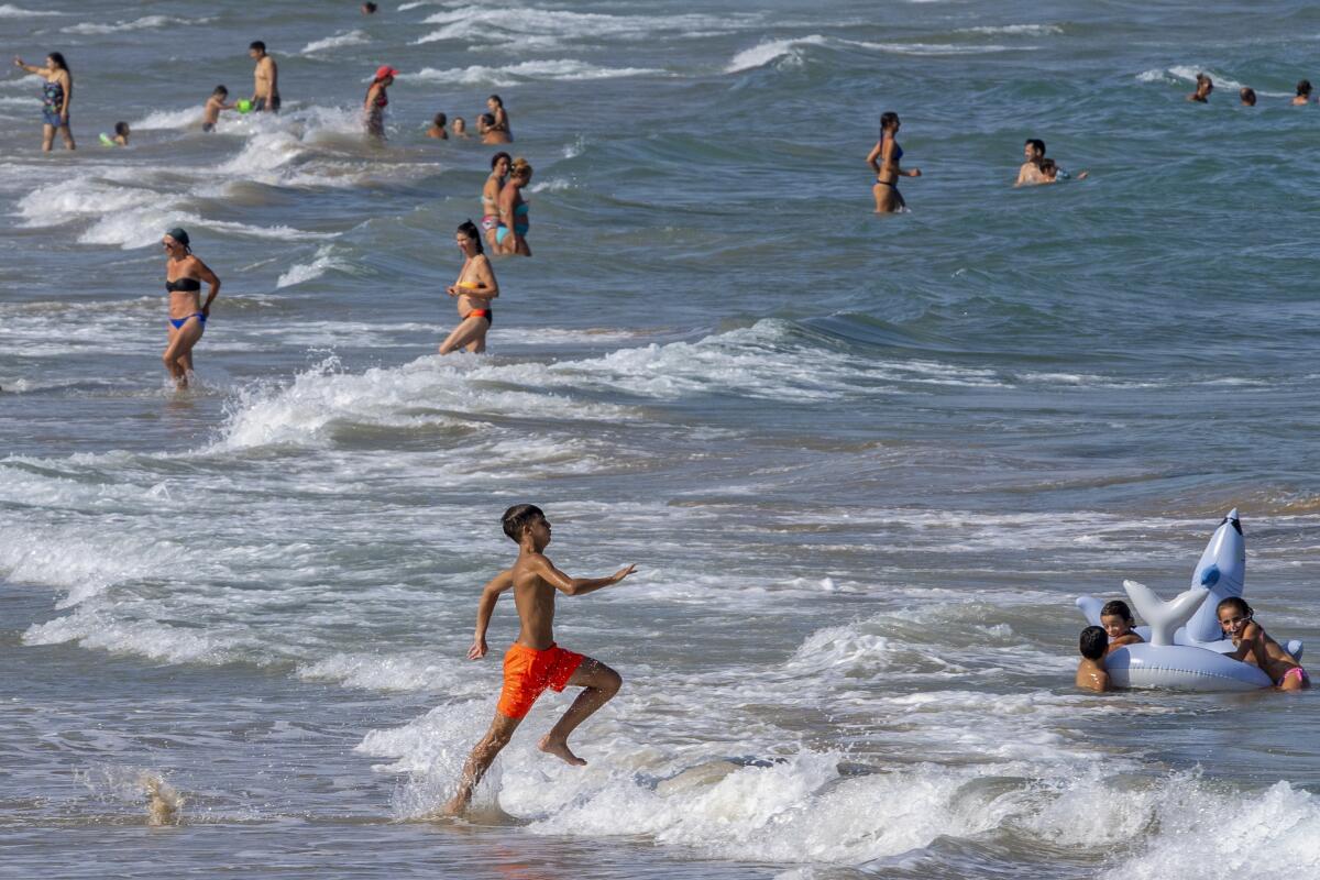 Gente refrescándose en la playa de Puerto de Sagunto, en el este de España