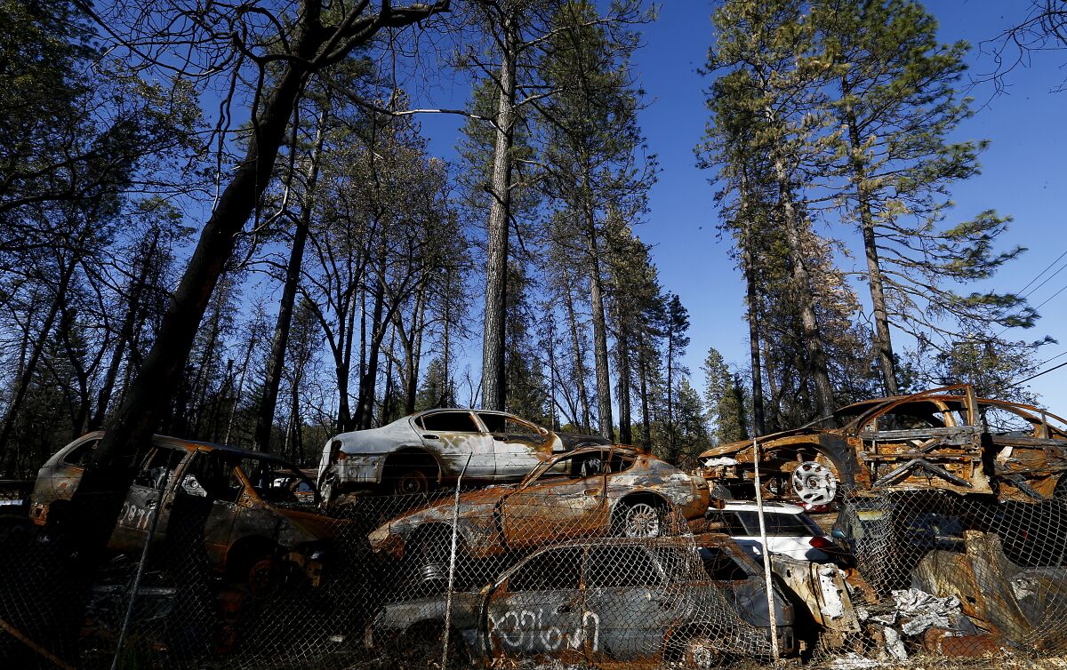 Charred cars from the Camp fire are stacked in a lot in Paradise