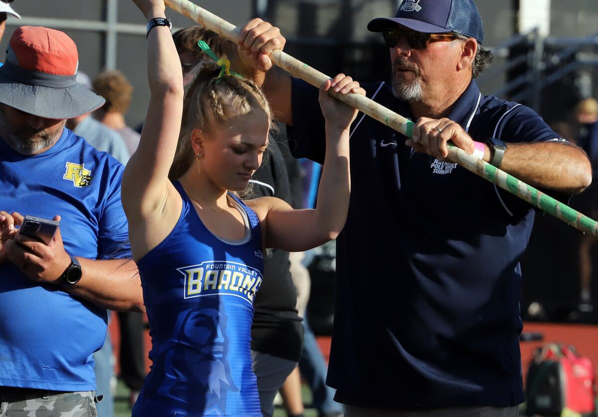 Fountain Valley's Izzy Abrahams gets assistance from a coach before her pole vault attempt in the Arcadia Invitational.