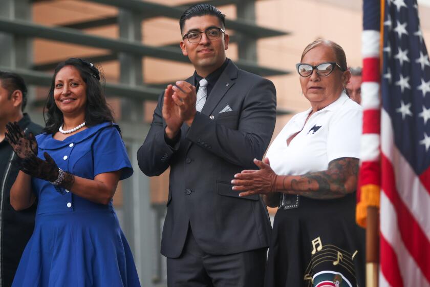 Wilmington, CA - June 27: (From left) Alicia Baltazar, Erick R. Ojeda Garcia, and Cynthia Guerra clap their hands while standing in front of the podium during a ceremony for the Wilmington Honorary Mayor announcement on Thursday, June 27, 2024 in Wilmington, CA. (Michael Blackshire / Los Angeles Times)