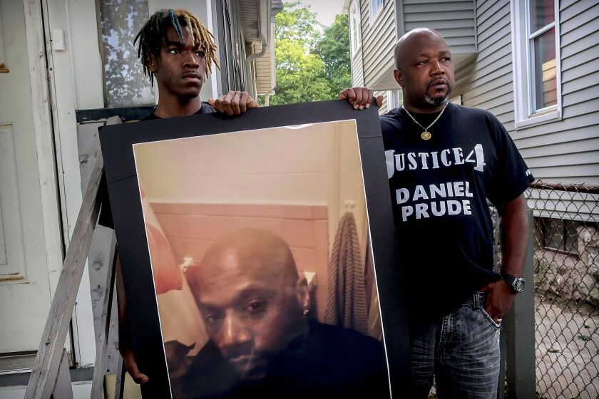 FILE - Armin Prude, left, and Joe Prude hold an enlarged photo of Daniel Prude, Sept. 3, 2020, who died following a police encounter, in Rochester, N.Y. City officials have agreed to pay $12-million to the family of Daniel Prude, a Black man who died after police held him down until he stopped breathing after encountering him running naked through the snowy streets of Rochester, NY. A federal judge approved the settlement in a court document filed Thursday, Oct. 6, 2022. (AP Photo/Ted Shaffrey, File)