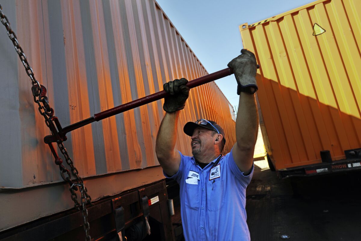 Jim Salazar loads a container onto his truck at New World Drayage, a container storage yard in Wilmington