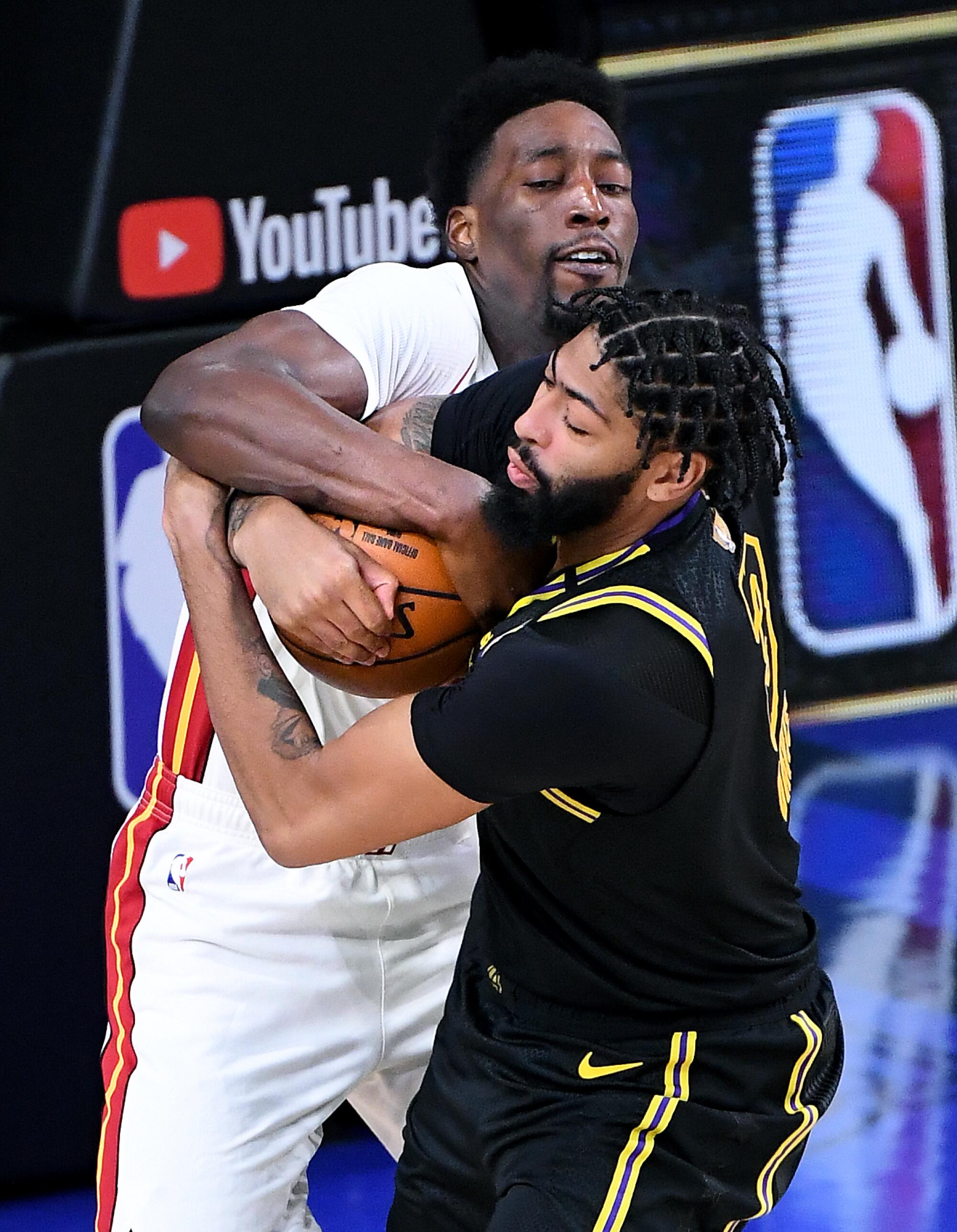Lakers forward Anthony Davis and Miami Heat forward Bam Adebayo battle for a loose ball.