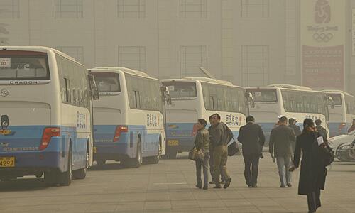 The Beijing Olympic clock, right, is barely visible as smog engulfs the Great Hall of People in Beijing, China.