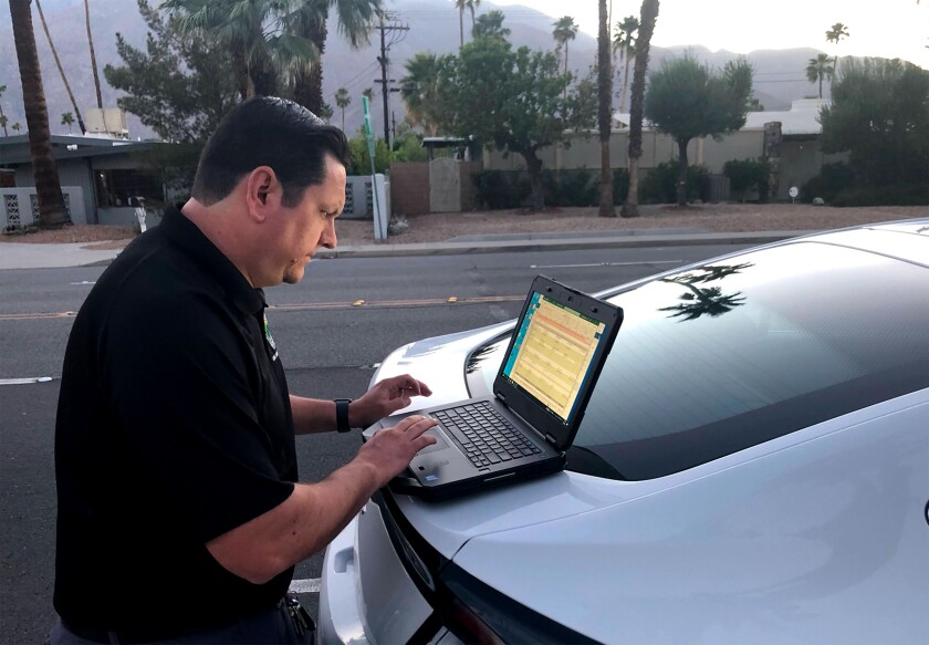 A man works on his laptop computer on top of a vehicle.