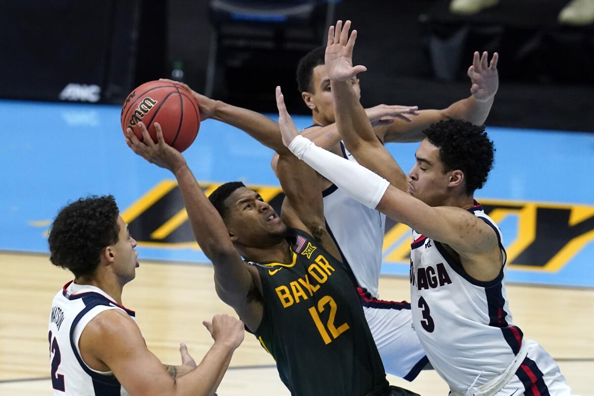 Baylor guard Jared Butler shoots between Gonzaga forward Anton Watson and guard Andrew Nembhard.