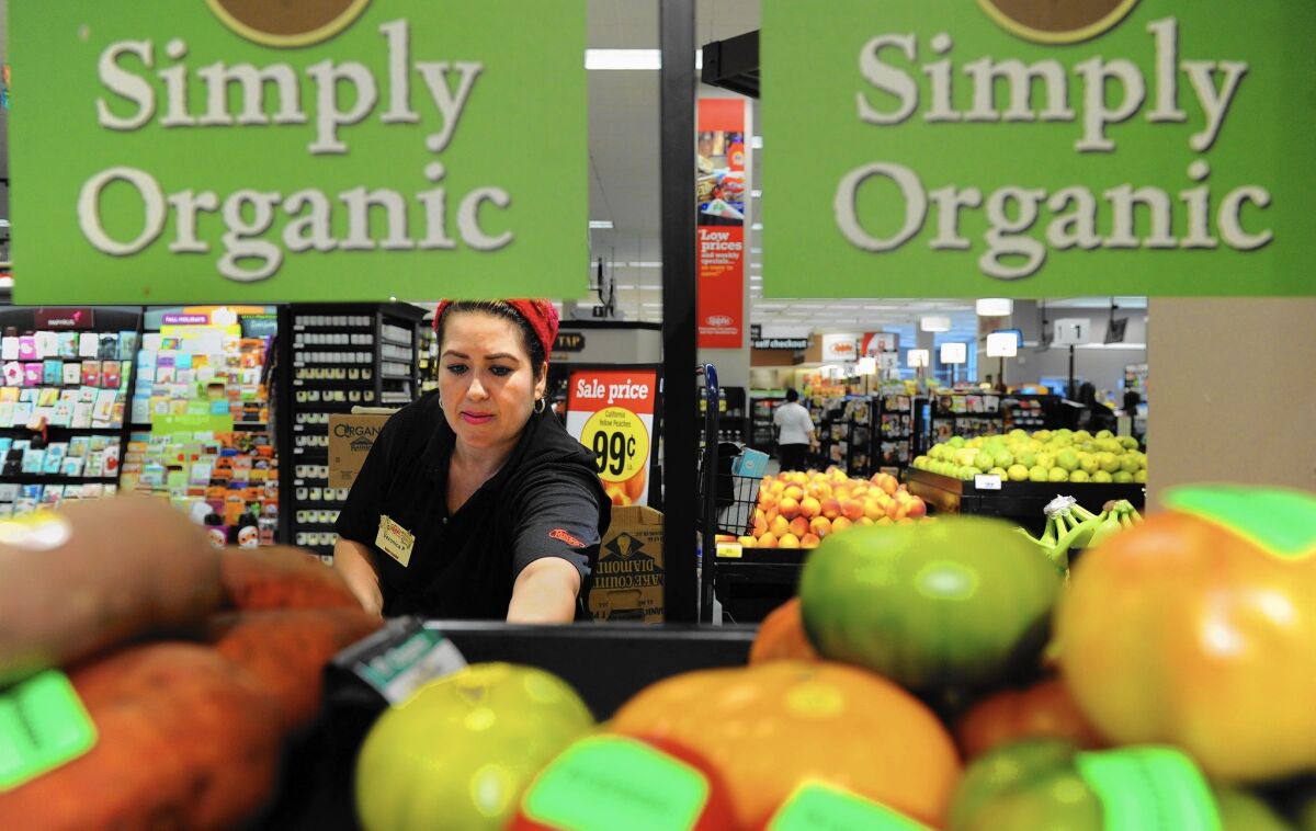 Southern California’s $44 billion in annual grocery sales makes it the largest U.S. grocery market by far. Above, produce clerk Veronica Padilla stocks apples at the Ralphs grocery store in downtown Los Angeles.
