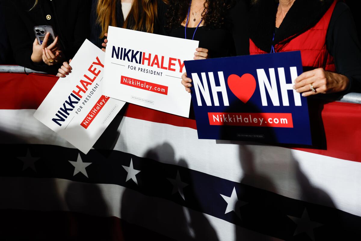 People hold signs supporting presidential candidate Nikki Haley