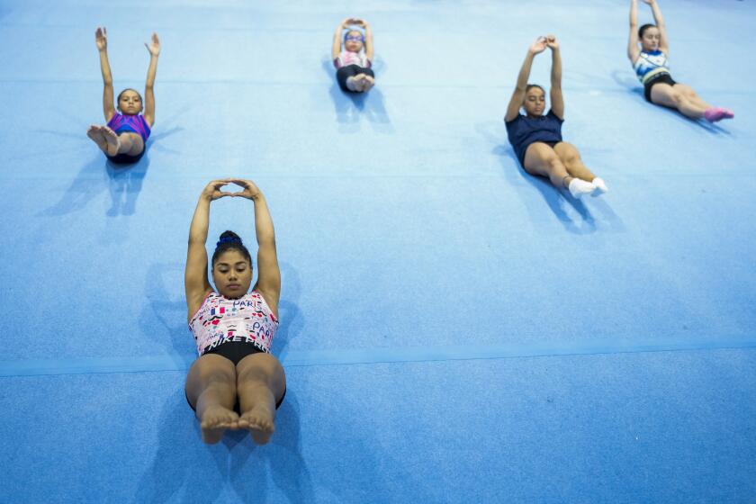La gimnasta panameña Hillary Heron realiza estiramientos en la capital de su país, el sábado 15 de junio de 2024, a fin de prepararse para los Juegos Olímpicos de París (AP Foto/Matias Delacroix)