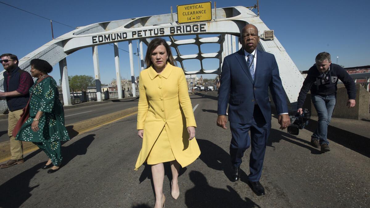 Rep. John Lewis walks with Joan M. Mooney, president of the Faith & Politics Institute, on the Edmund Pettus Bridge on Sunday, March 4, 2018, in Selma, Ala., during the annual commemoration of "Bloody Sunday."