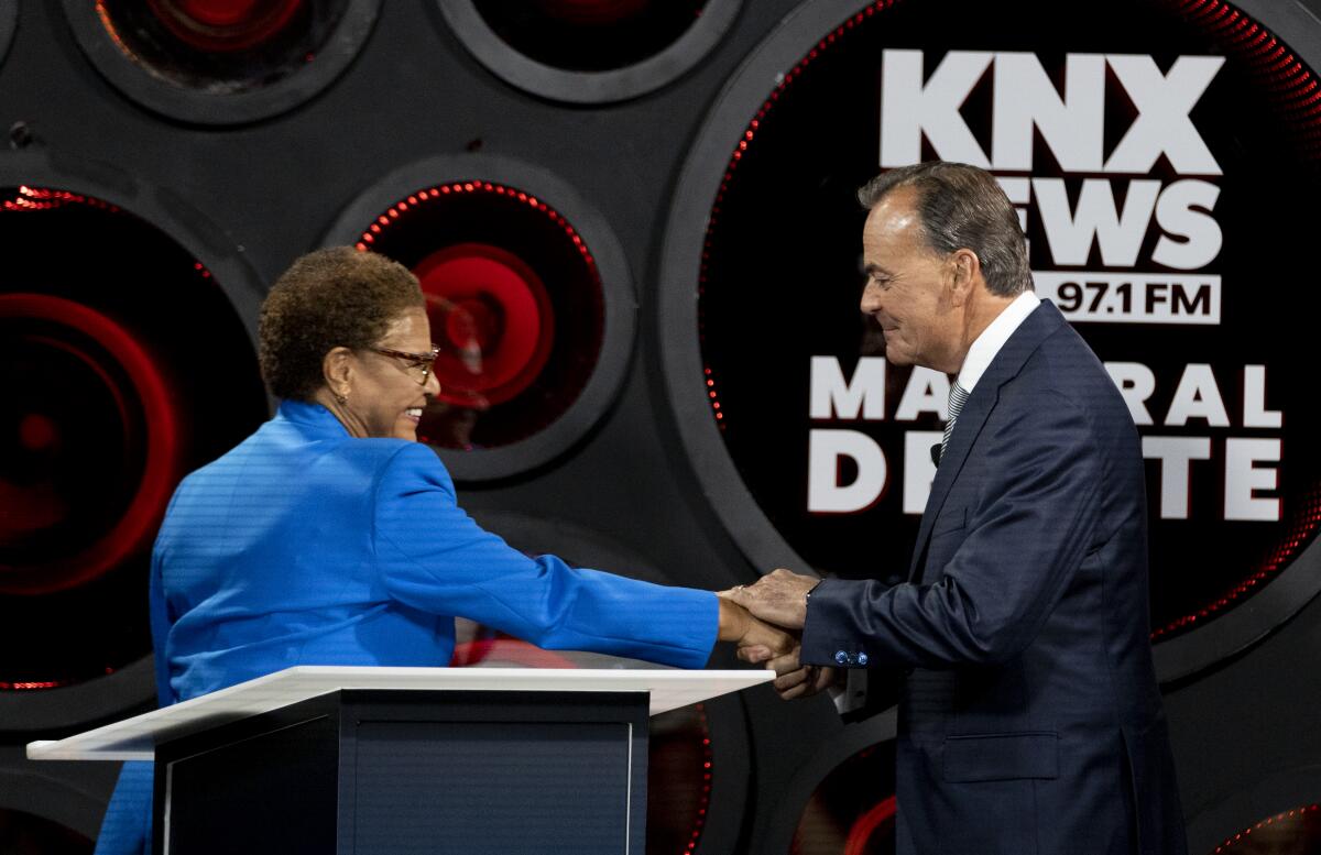 Mayoral candidates Karen Bass and Rick Caruso greet each other at Thursday's KNX News debate.