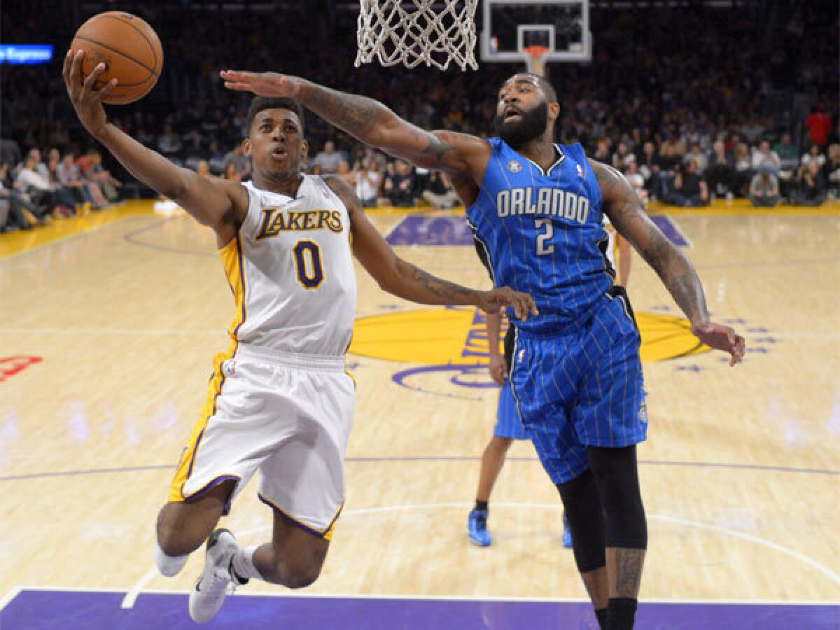 Lakers forward Nick Young, left, puts up a shot against Orlando forward Kyle O'Quinn at Staples Center on Sunday night.