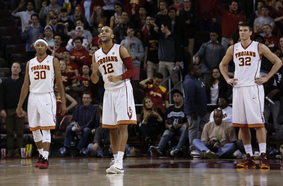 Julian Jacobs (12) celebrates with teammates Elijah Stewar (30), and Nikola Jovanovic (32) during USC's 79-72 victory over Colorado on Feb. 17 at the Galen Center.