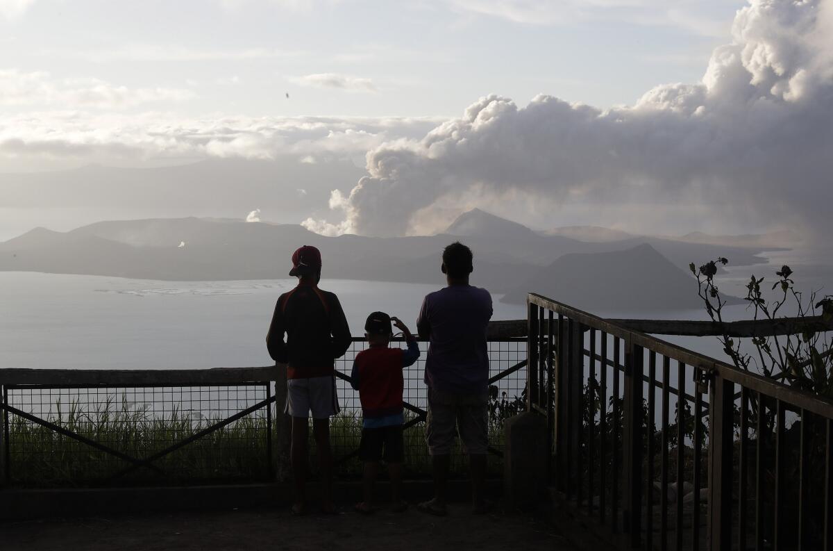 People watch the Taal volcano  Jan. 14 from Tagaytay, Philippines. The volcano is in the middle of a lake in Batangas province south of Manila.