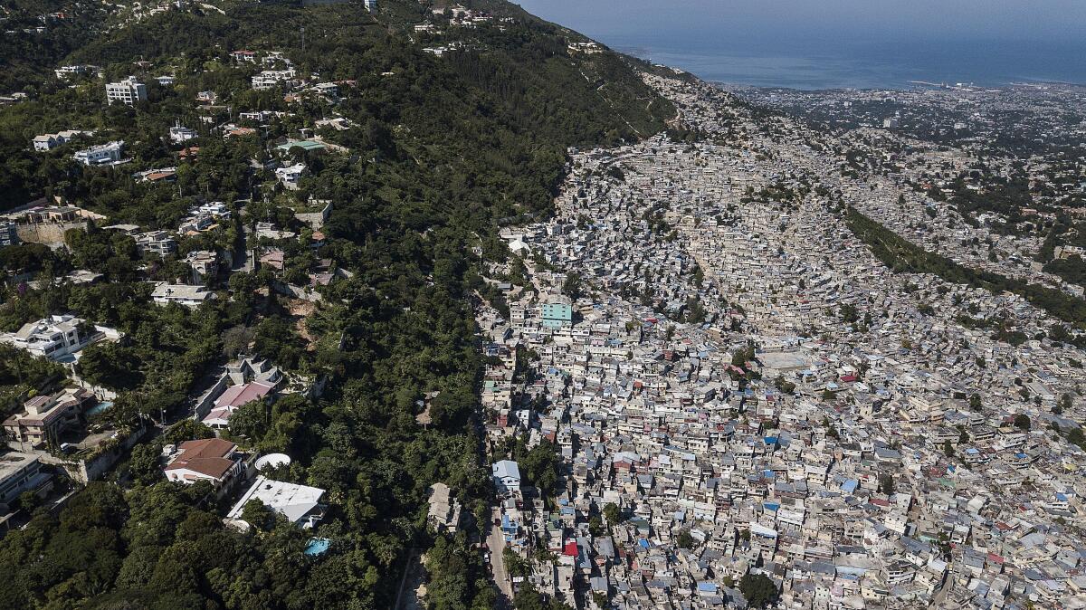 Trees separate an affluent neighborhood, Morne Calvaire, from densely populated homes in the Jalouise neighborhood of Port-au-Prince, Haiti, Friday, Nov. 5, 2021. (AP Photo/Matias Delacroix)