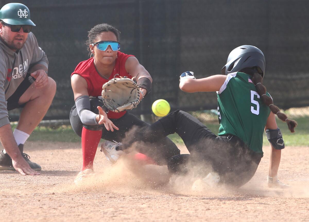 Costa Mesa's Victoria Rios (5) slides under the tag safely at third base against Pasadena Mayfield on Thursday.