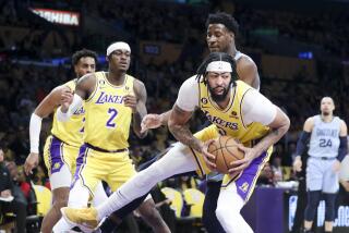 LOS ANGELES, CALIF. - MAR. 7, 2023. Los Angeles Lakers center Anthony Davis pulls down a rebound during the first half against the Memphis Grizzlies in an NBA game at Crypto.com Arena in Los Angeles on Tuesday, Mar. 7, 2023. (Luis Sinco / Los Angeles Times)