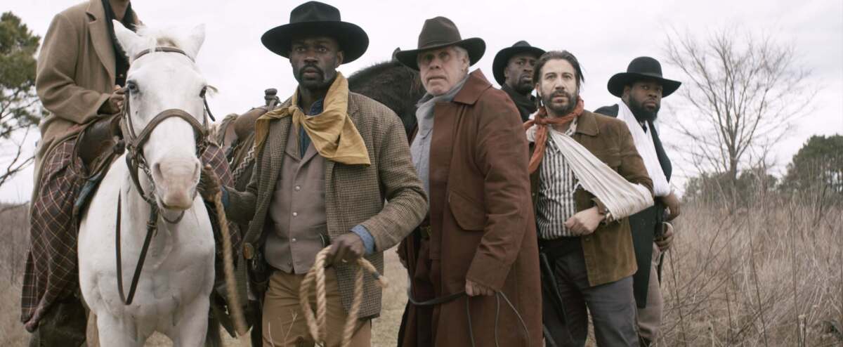 David Gyasi, holding horse, and Ron Perlman in the movie “Hell on the Border.”