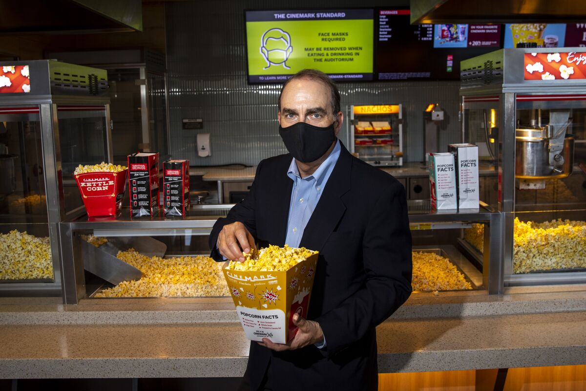 Cinemark CEO Mark Zoradi holding a bucket of popcorn