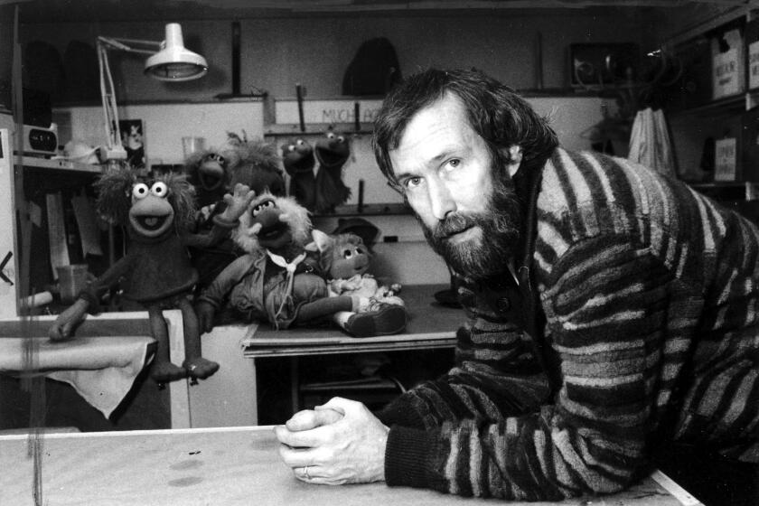FILE- In this Feb. 6, 1984, file photo, Jim Henson with his "Muppets" pose for a photo at Henson's 69th Street office in New York. A New York City museum is asking fans of Jim Henson's Muppets to help pay for an exhibition featuring original puppets of beloved characters like Elmo, Miss Piggy and Kermit the Frog. The Museum of the Moving Image launched a Kickstarter campaign Tuesday, April 11, 2017, seeking $40,000 to help preserve the puppets for posterity. (AP Photo/G. Paul Burnett, File)