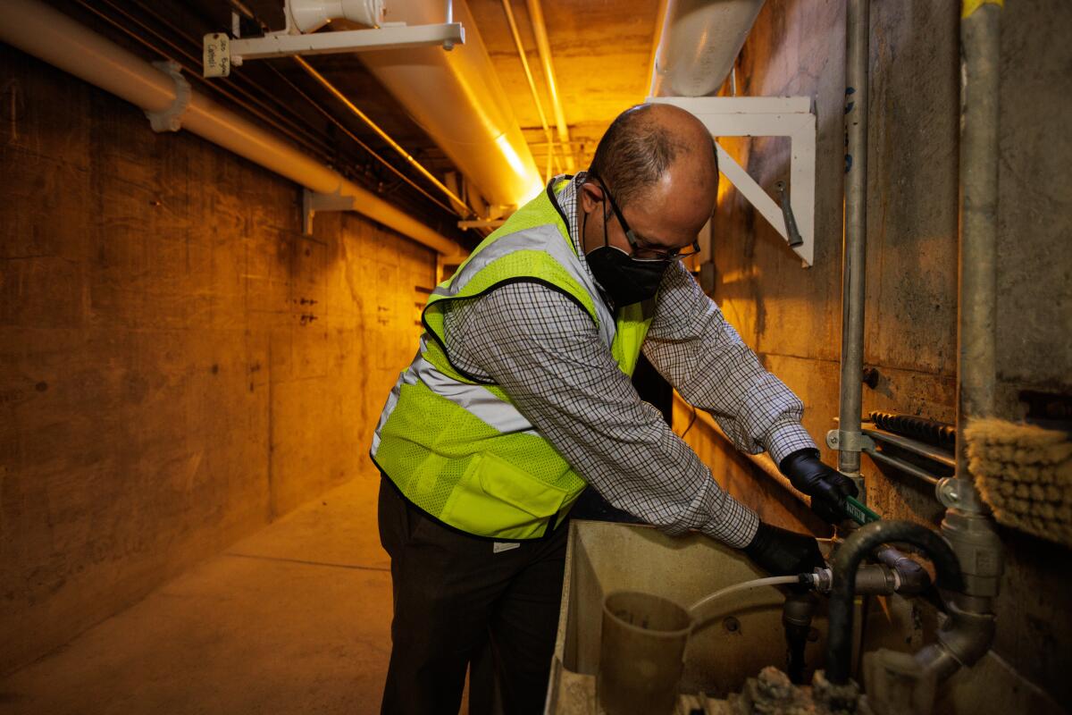 Amit Mutsuddy demonstrates how agency staff collects primary sludge samples to send to a lab to test for various viruses.