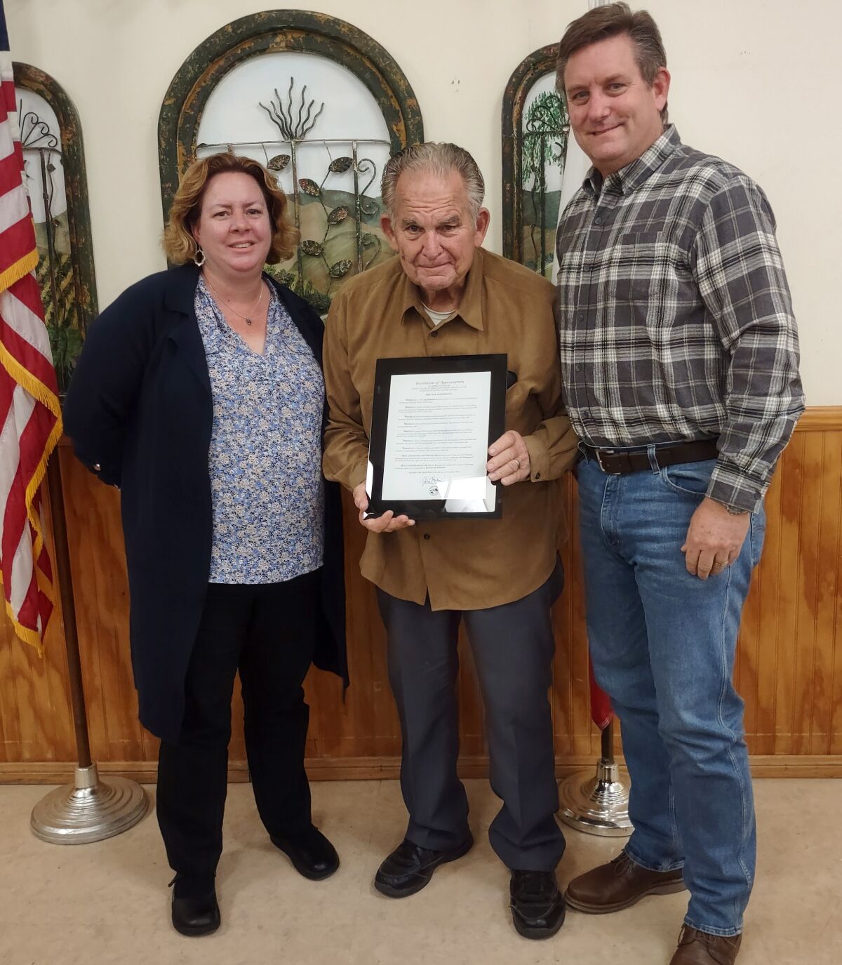 Jim Robinson, center, accepts his Resolution of Appreciation from General Manager Erica Wolski and Director Jeff Lawler.