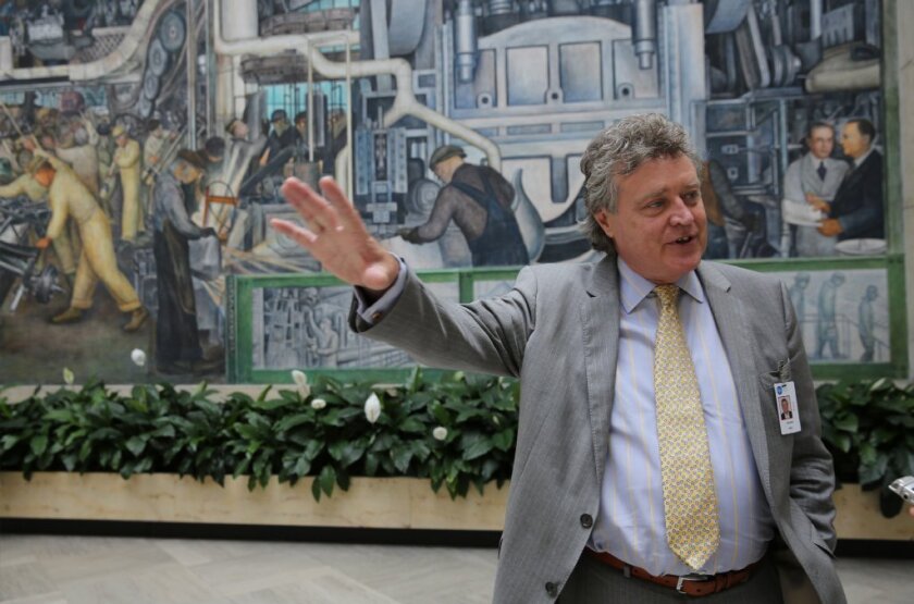 Graham Beal will retire in June after 16 years as director of the Detroit Institute of Arts. He's pictured here in 2013 next to a famous Diego Rivera mural at the museum.