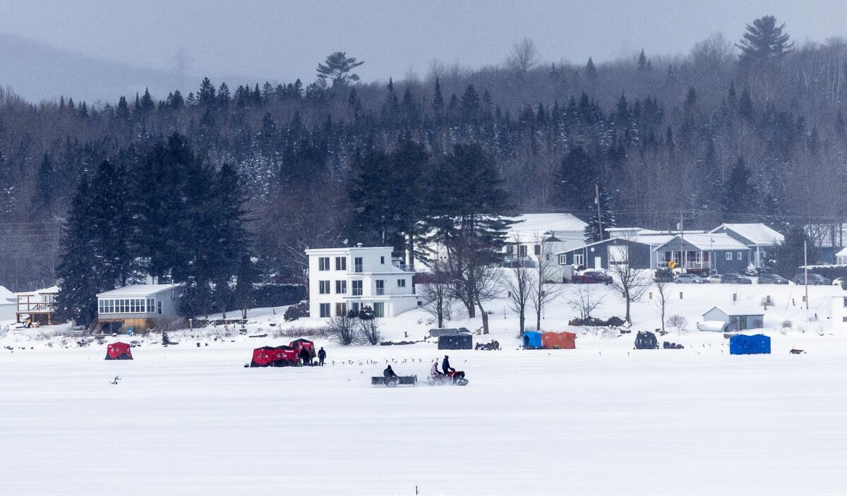  Ice fisherman and snowmobilers on the Canadian side of Lake Wallace as seen from the U.S. side.