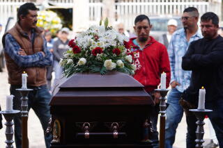 Men stand near a coffin.