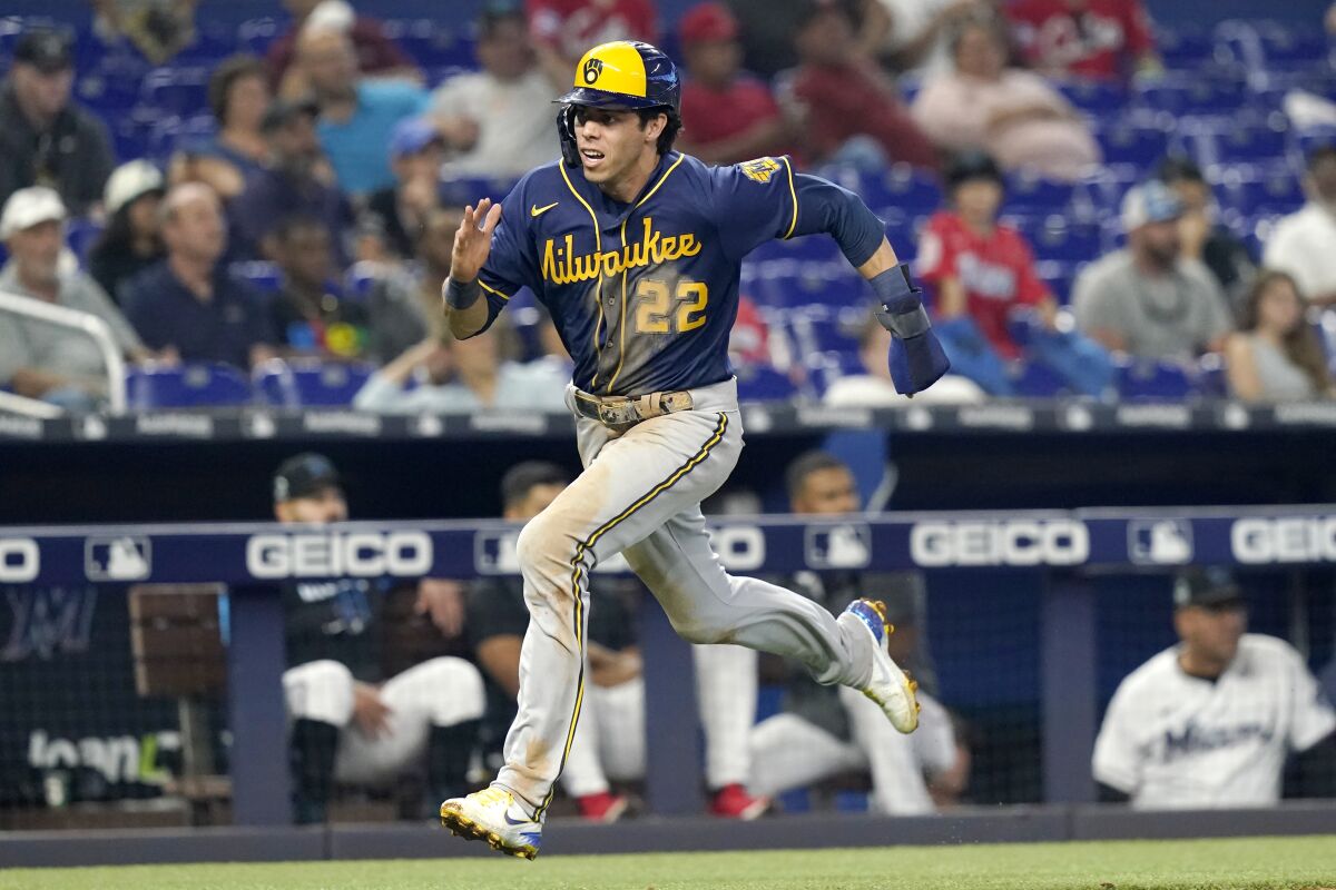 Milwaukee Brewers' Christian Yelich (22) runs to score on a single hit by Omar Narvaez during the fifth inning of a baseball game against the Miami Marlins, Sunday, May 15, 2022, in Miami. (AP Photo/Lynne Sladky)
