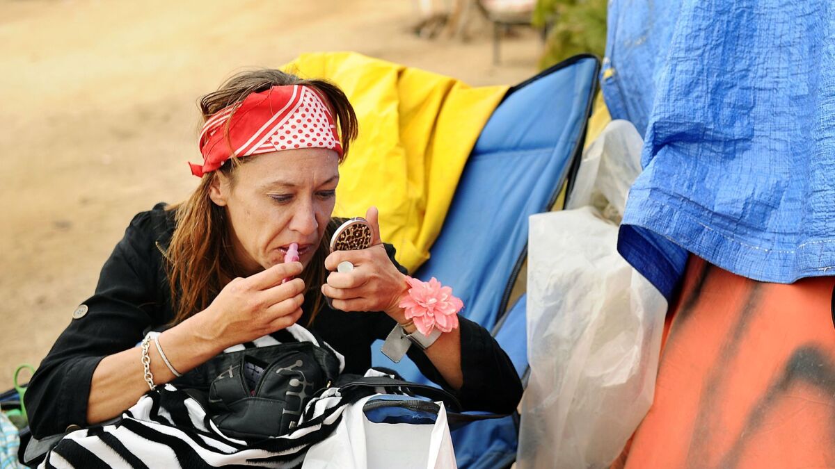 Vicky Buskirk applies lip gloss outside her friend's tent.