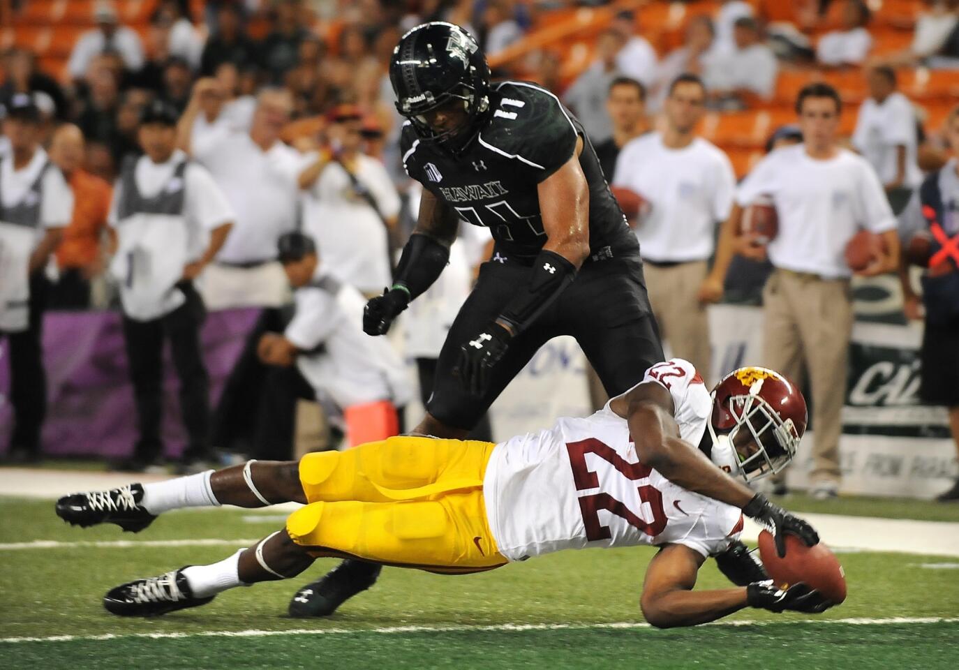 Trojans running back Justin Davis dives into the end zone before Hawaii's Tavita Woodard can stop him from scoring in the fourth quarter Thursday night at Aloha Stadium in Honolulu.