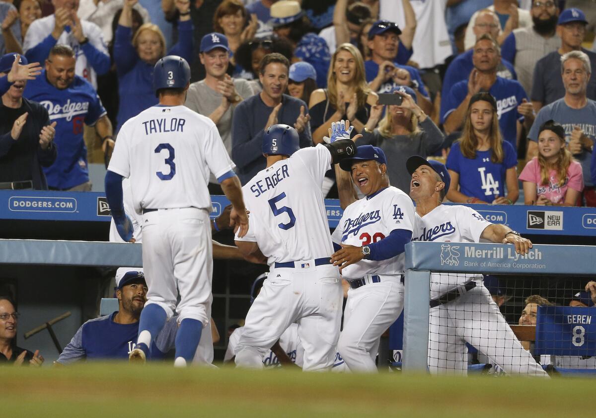 Dodgers shortstop Corey Seager gets high-fives at the dugout after hitting his second homer of the night, a two-run shot, against the San Francisco Giants during a game earlier this season.