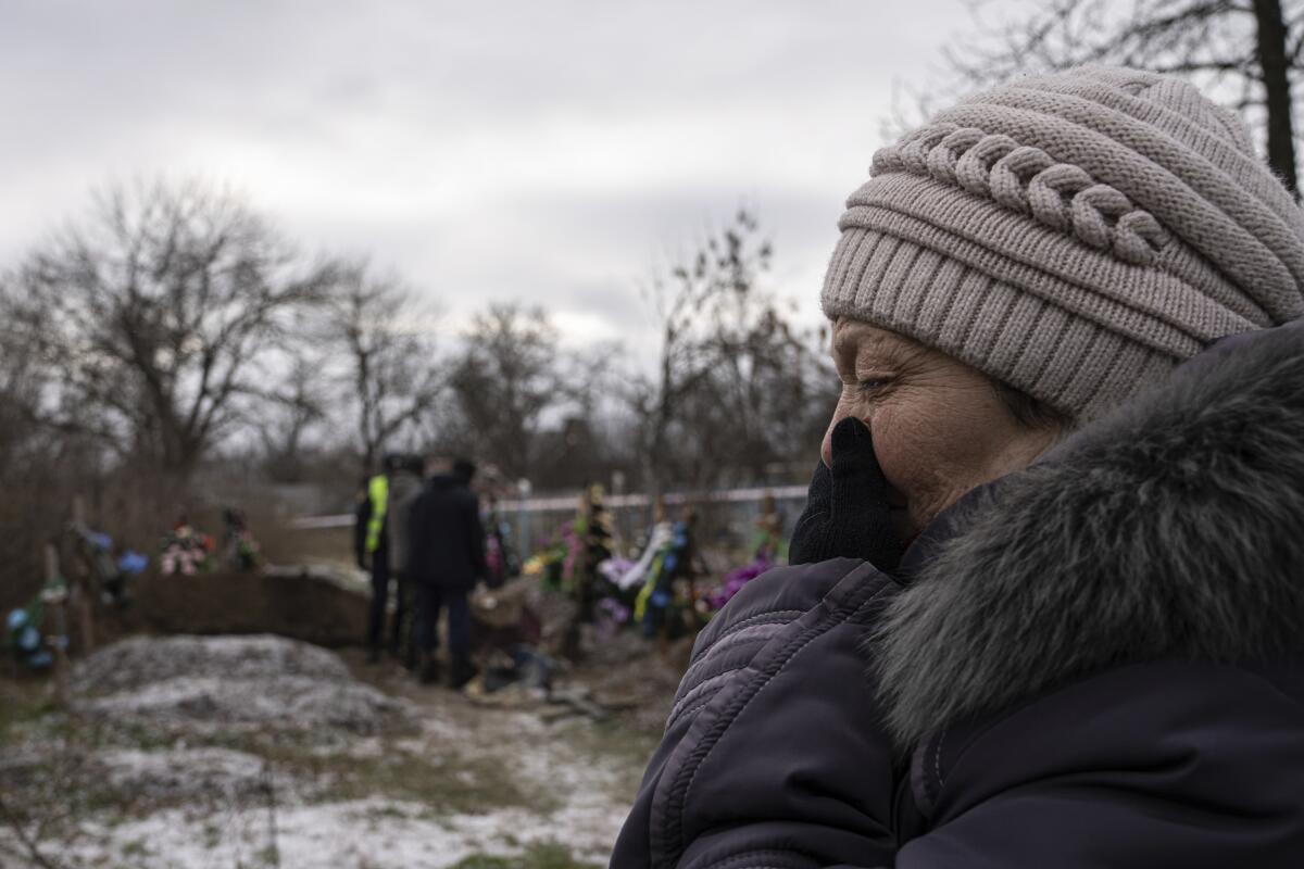 A woman in parka and hat cries 