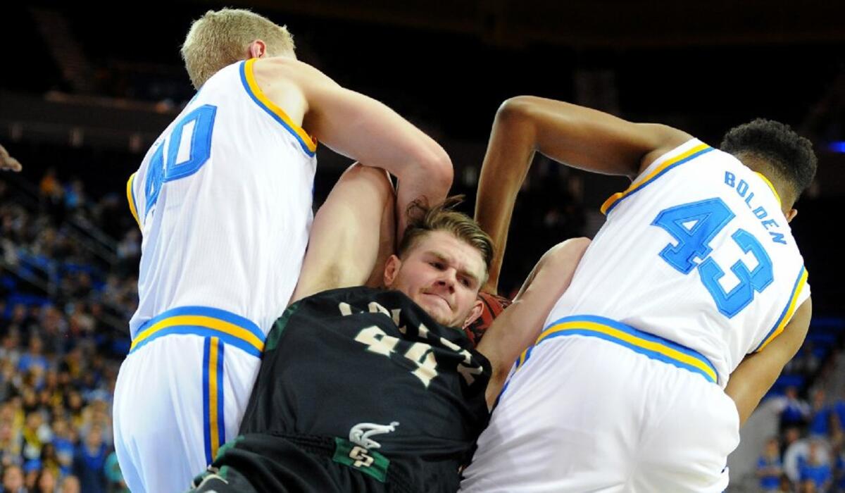 Cal Poly's Zach Gordon is tied up on a rebound by UCLA center Thomas Welsh, left, and forward Jonah Bolden during the first half.