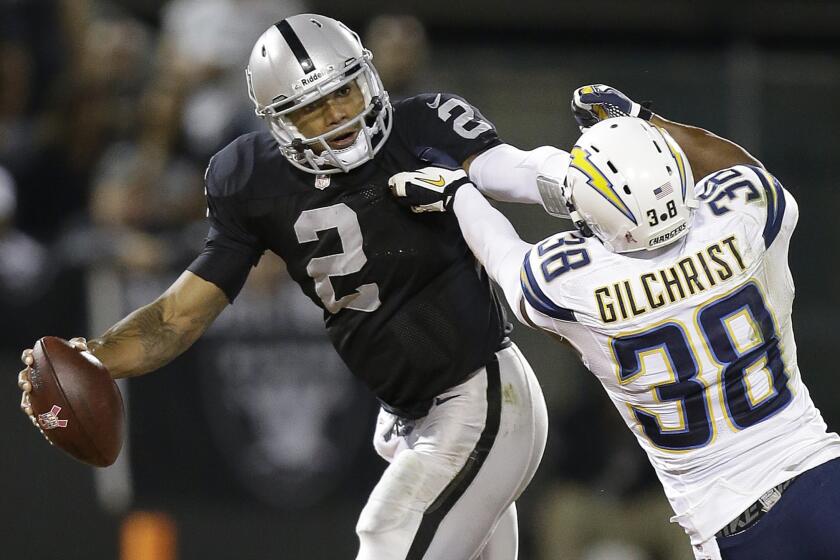 Oakland quarterback Terrelle Pryor tries to break a tackle attempt by San Diego Chargers strong safety Marcus Gilchrist during the Raiders' 27-17 win Sunday night.