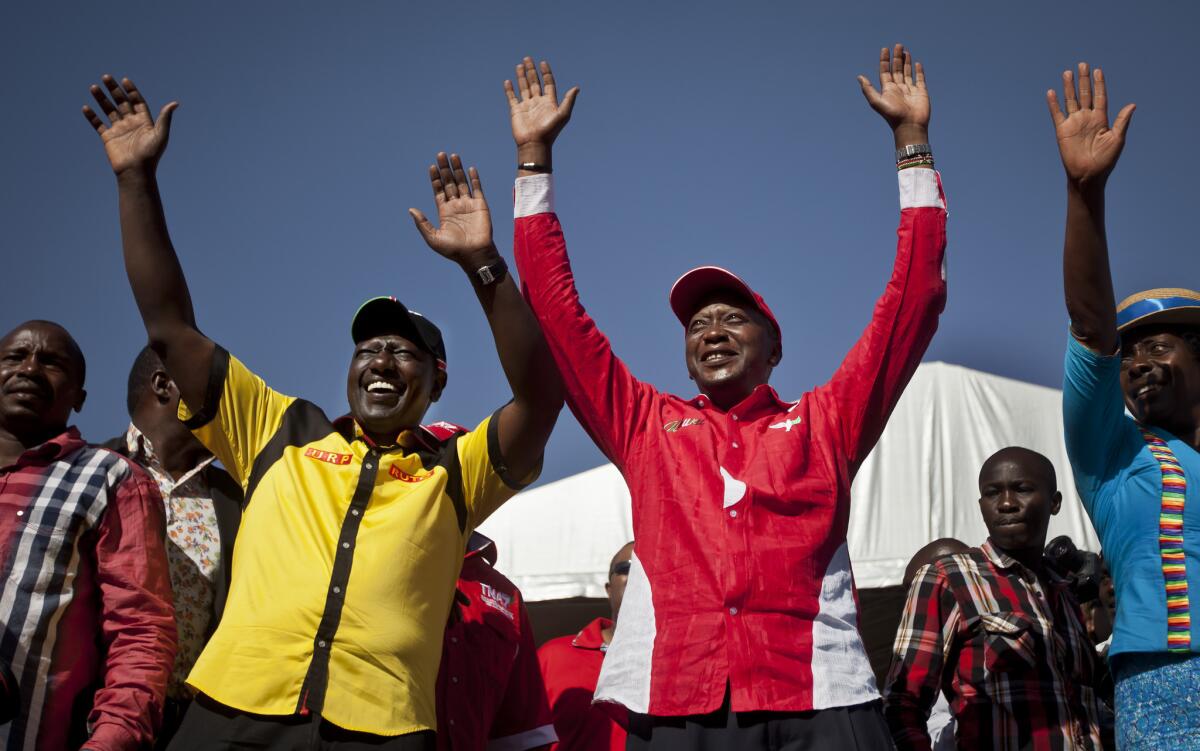 Then- Kenyan presidential candidate Uhuru Kenyatta, center right, and his running mate William Ruto, center left, greet the crowd as they arrive at the final election rally of Kenyatta's The National Alliance party at Uhuru Park in Nairobi in March.