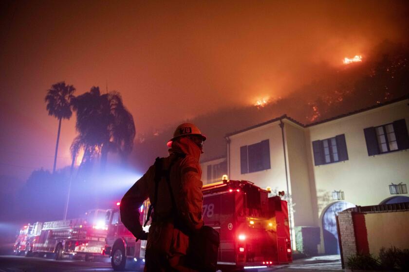 A firefighter watches a flames approach the Mandeville Canyon neighborhood during the Getty fire, Monday, Oct. 28, 2019, in Los Angeles, Calif. (AP Photo/ Christian Monterrosa)