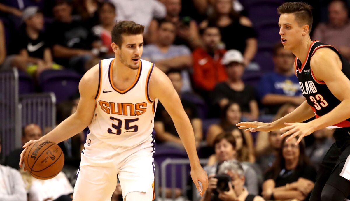 Suns forward Dragan Bender looks to drive against Trail Blazers forward Zach Collins during a game this season. Bender, the No. 4 pick in the 2016 draft, rarely plays.