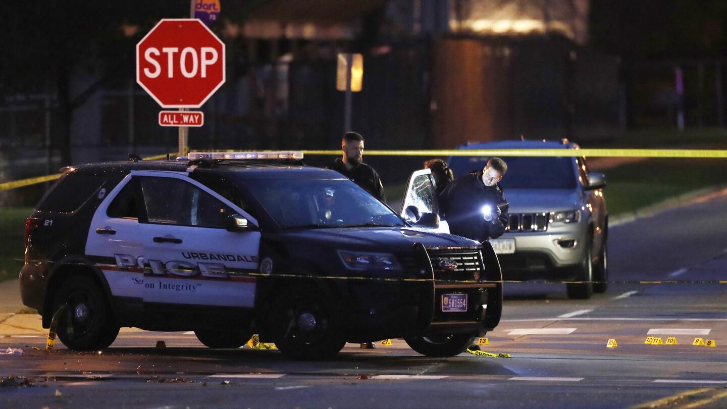 Police officers gather evidence at the scene of a shooting on Wednesday in Urbandale, Iowa. Two Des Moines-area police officers were shot to death early Wednesday in ambush-style attacks while they were sitting in their patrol cars, authorities said.
