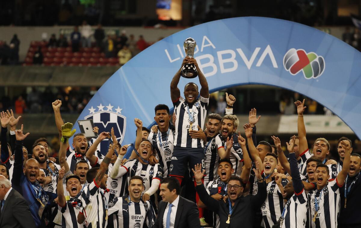 Dorlan Pabon (centro) levanta el trofeo de campeón en la Liga MX.