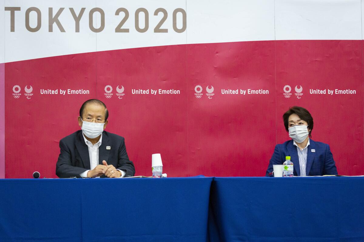 El director general de los Juegos de Tokio, Toshiro Muto, izquierda, 