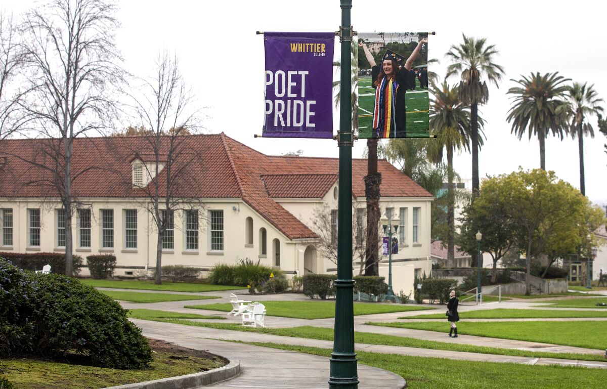 A woman walks on a college campus.